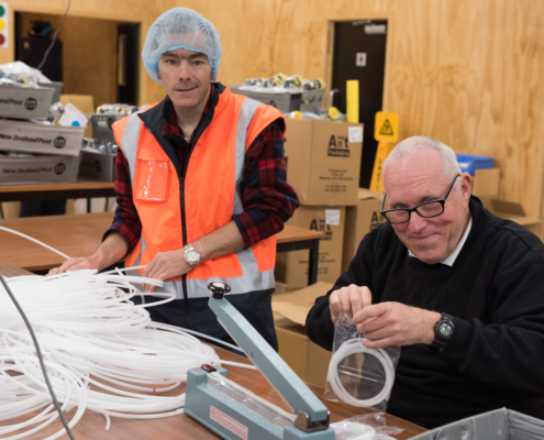 alt=two men collating plastic tubing kits